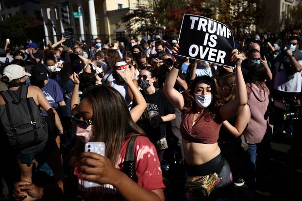 People react as media announce that Democratic U.S. presidential nominee Joe Biden has won the 2020 U.S. presidential election in Washington