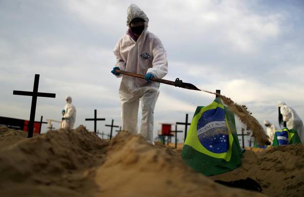 Activists of the NGO Rio de Paz in protective gear dig graves on Copacabana beach to symbolise the dead from the coronavirus disease (COVID-19) during a demonstration in Rio de Janeiro