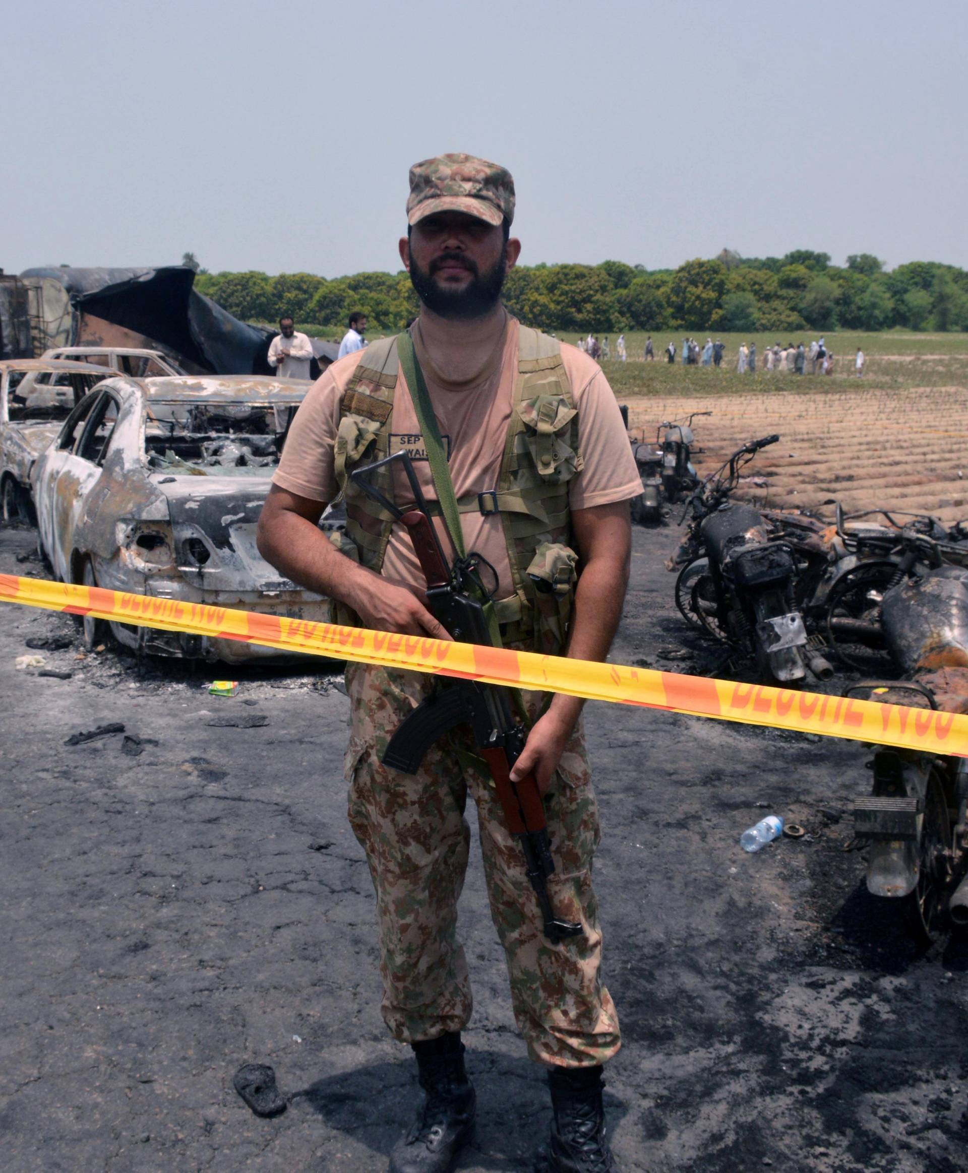 Soldier stands guard at the scene of an oil tanker explosion in Bahawalpur