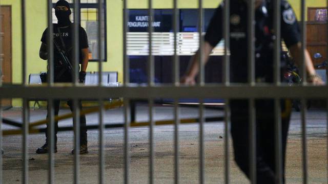 Police stand guard at the gate of the morgue at Kuala Lumpur General Hospital where Kim Jong Nam's body is held for autopsy in Malaysia