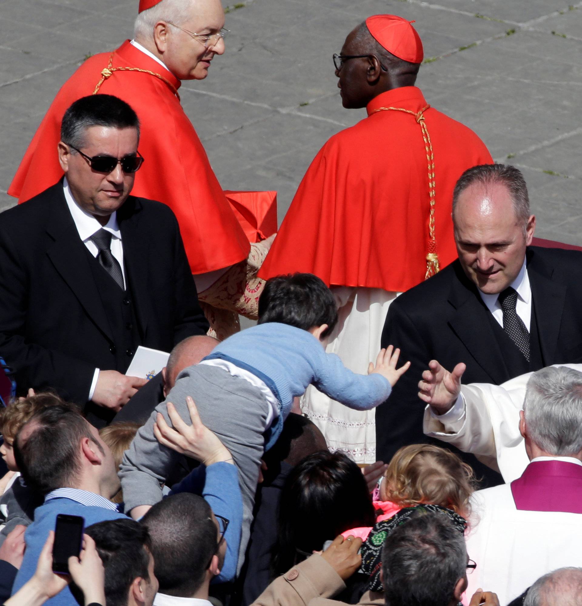 Pope Francis greets a child at the end of the Easter Mass at St. Peter's Square at the Vatican