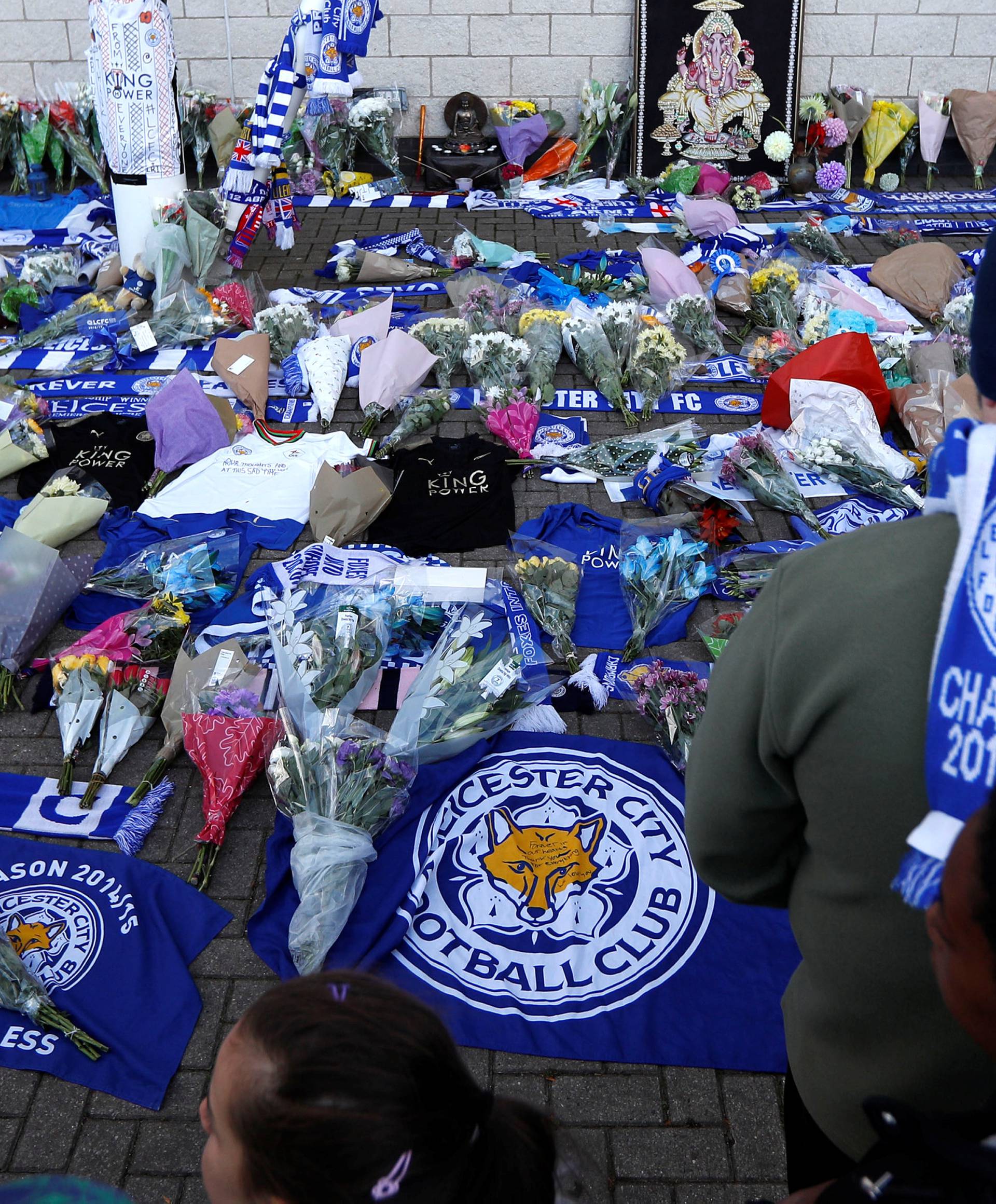 Leicester City football fans pay their respects outside the football stadium, after the helicopter of the club owner Thai businessman Vichai Srivaddhanaprabha crashed when leaving the ground on Saturday evening after the match, in Leicester