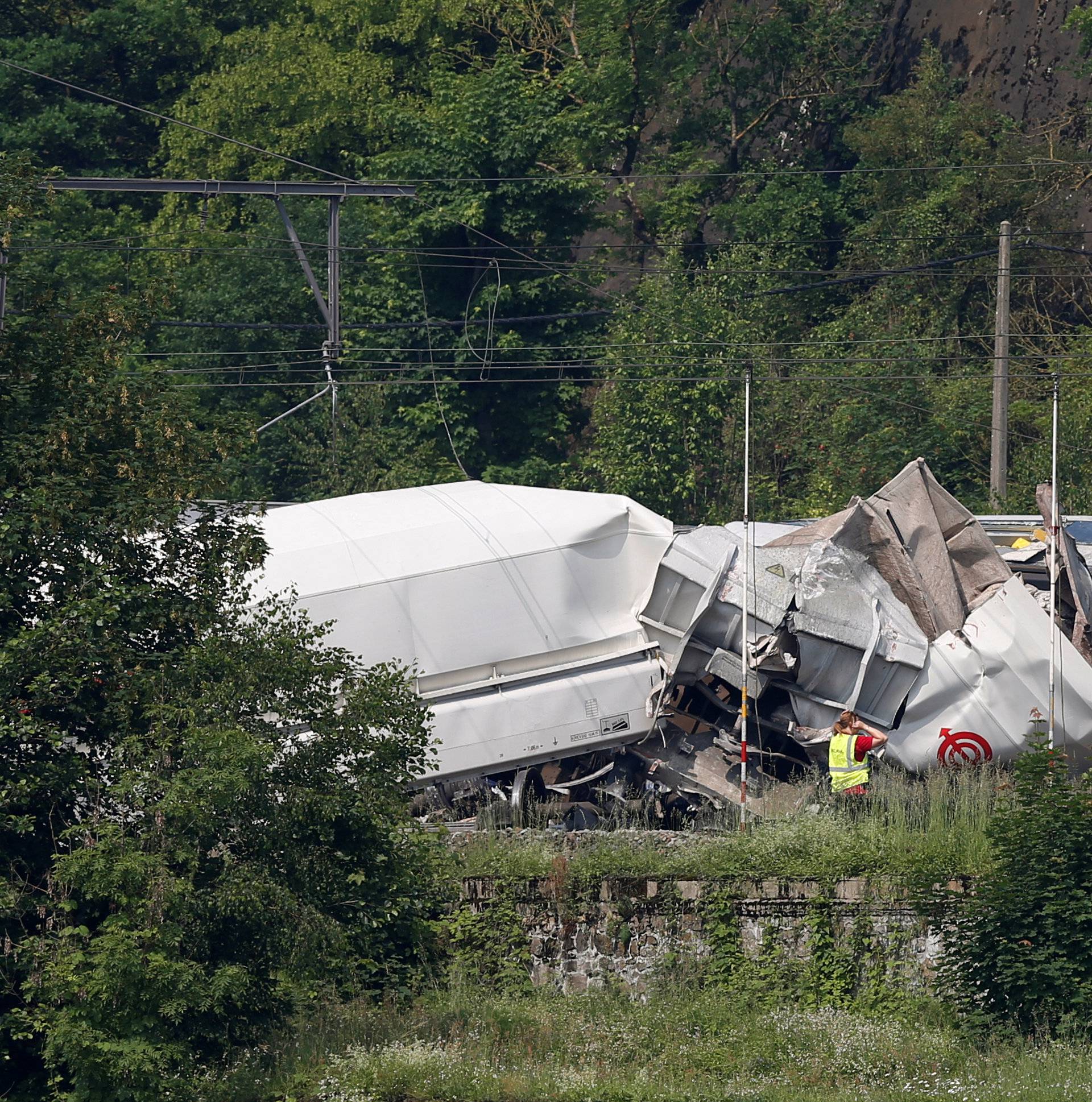 An official inspects the wreckage of a passenger train after it crashed into the back of a freight train in the eastern Belgian municipality of Saint-Georges-Sur-Meuse