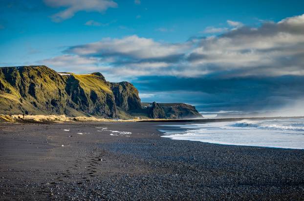 Black Beach and Sea-stacks in Vik Iceland with mountains waves a