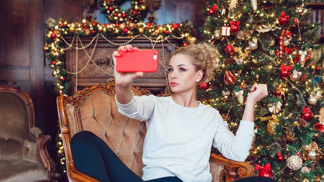 Young pretty blonde woman sitting on a chair near Christmas