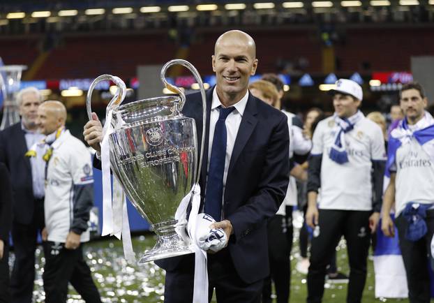 Real Madrid coach Zinedine Zidane celebrates with the trophy after winning the UEFA Champions League Final