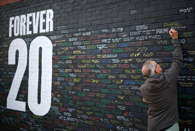 FILE PHOTO: A fan adds a message to a memorial wall created near Anfield Stadium following the death of Liverpool soccer player Diogo Jota in Liverpool