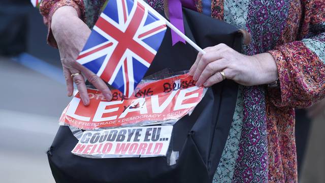 A vote leave supporter holds a poster in Westminster, London