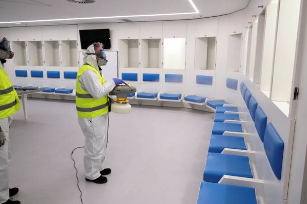 Cleaners wearing protective suits sanitise locker rooms at the San Paolo stadium ahead of the second leg of the Coppa Italia semi-final between Napoli and Inter Milan, which has since been postponed