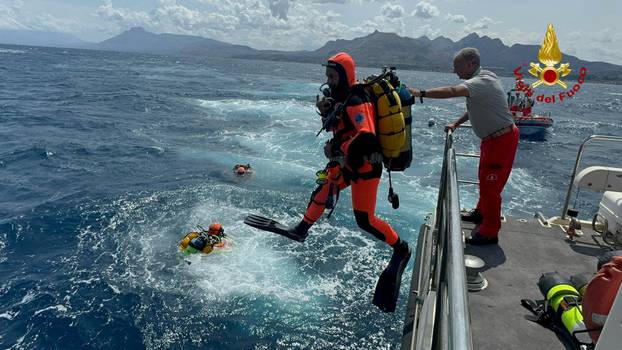 Divers operate in the sea to search for the missing after a luxury yacht sank off Sicily