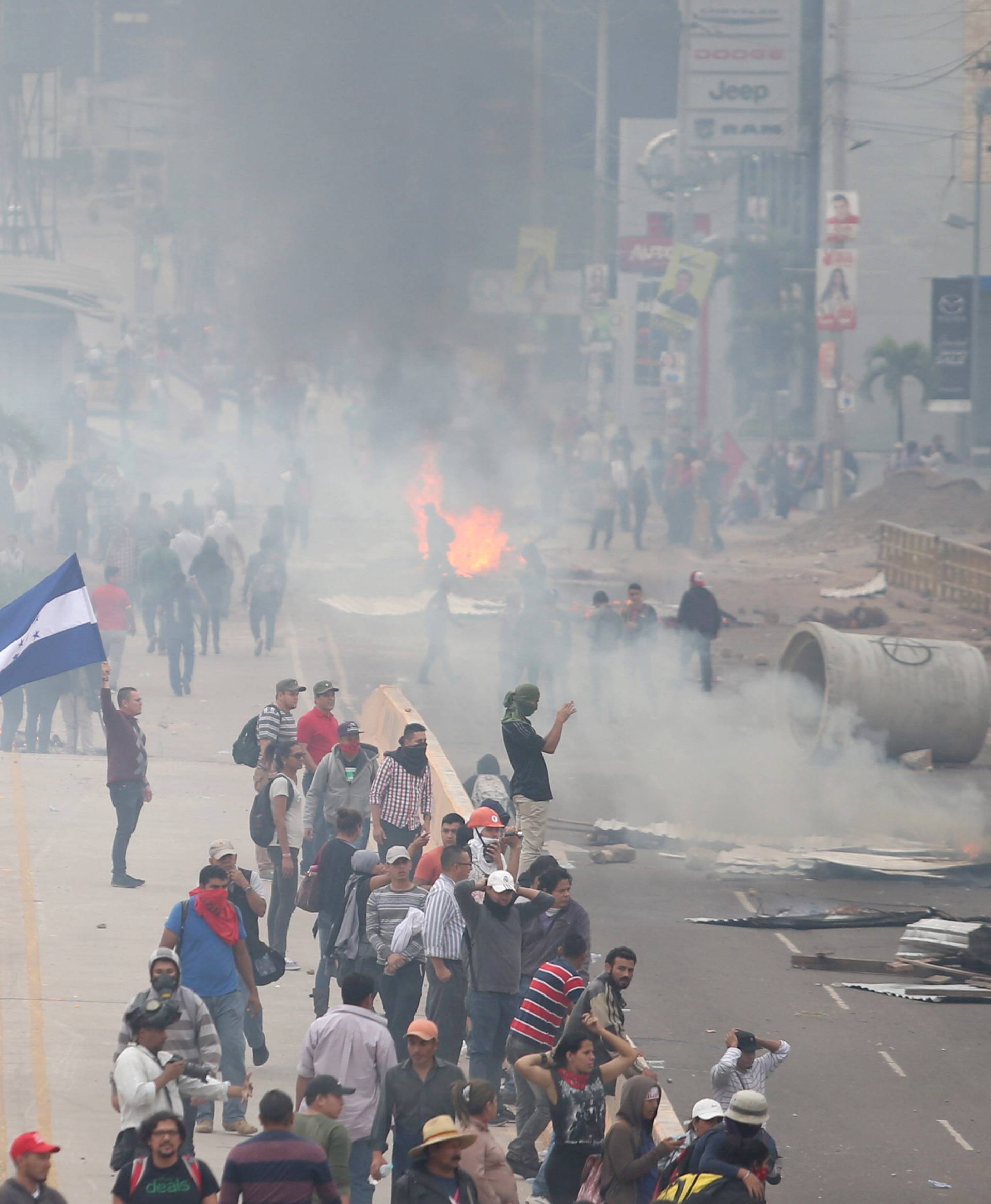 Supporters of presidential candidate Nasralla clash with riot police as they wait for official presidential election results in Tegucigalpa