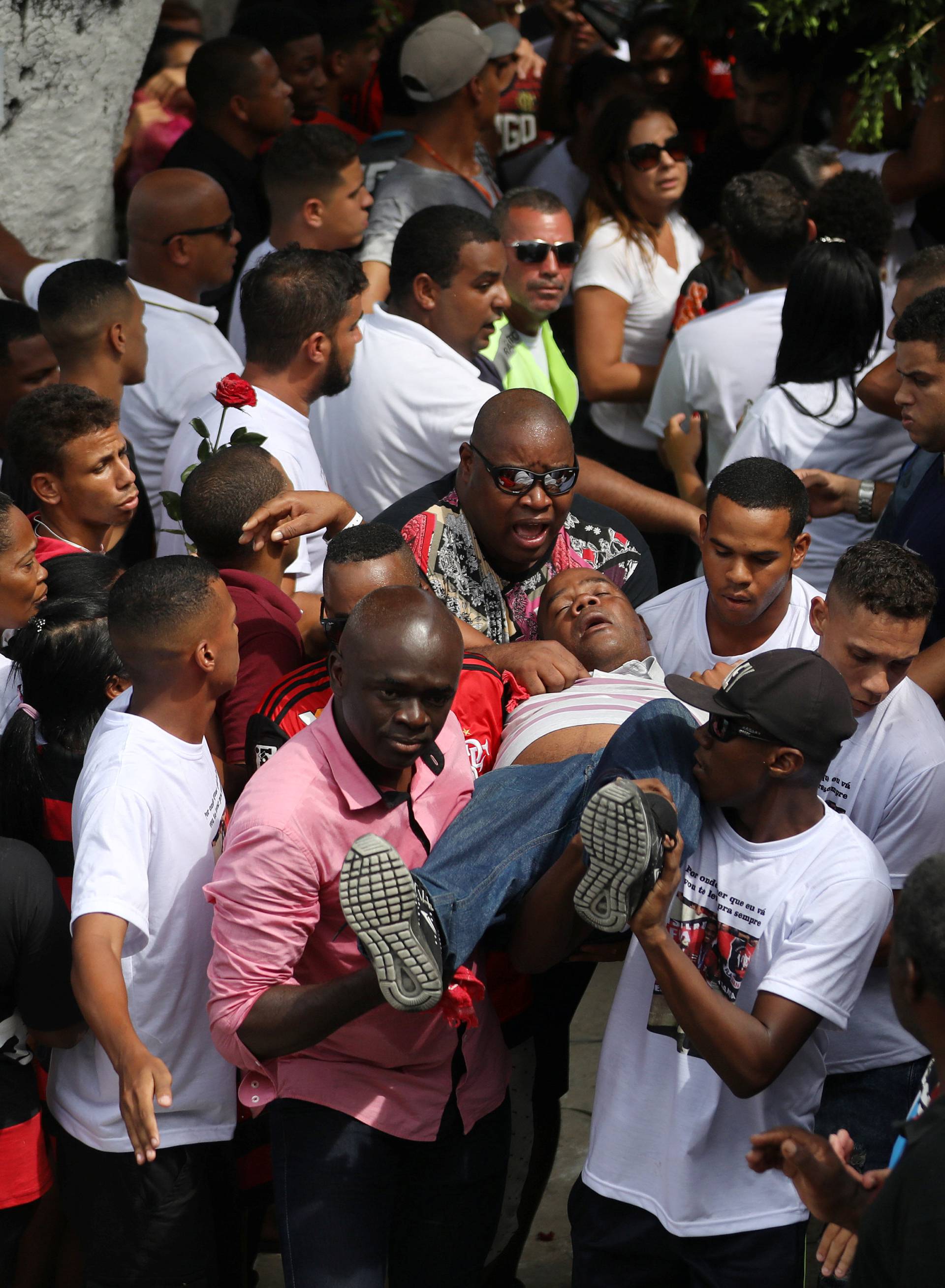 The uncle of teenage soccer player Samuel Thomas de Souza Rosa, who died in the fire that swept through Flamengo's training ground, is being helped during the funeral of his nephew, in Rio de Janeiro