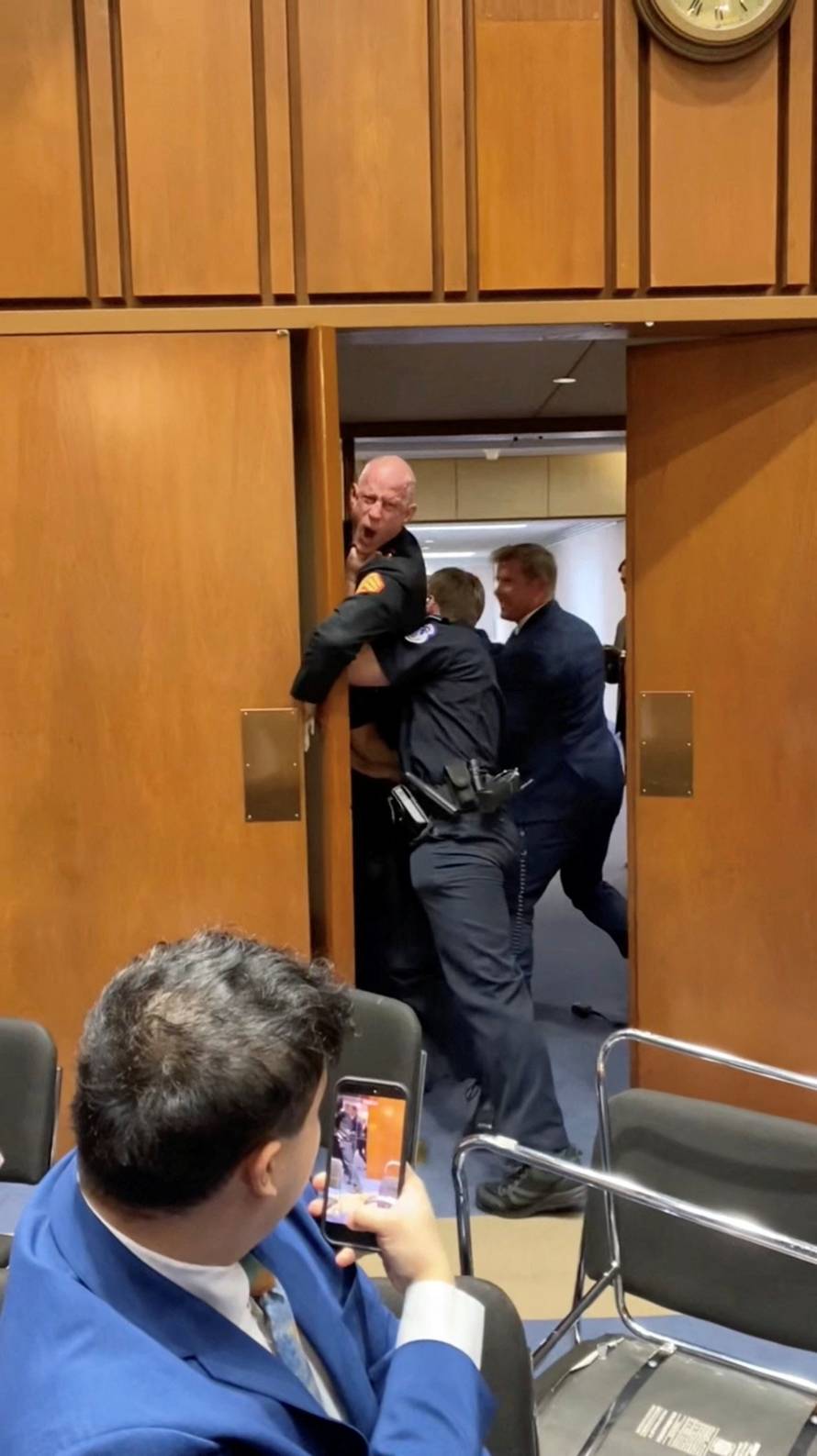 Former Marine Sgt. Brian McGuinness is dragged out during the Senate Armed Services subcommittee hearing, in Washington