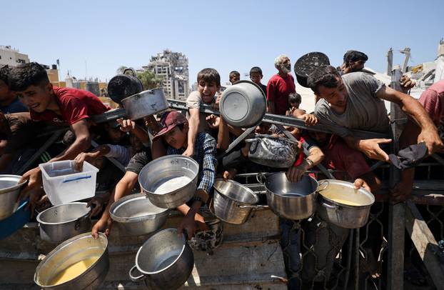 Palestinians receive food from charity kitchen, in Gaza City