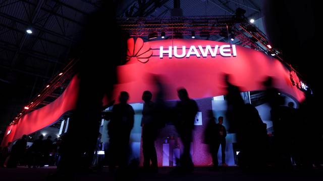 FILE PHOTO - Visitors walk past Huawei's booth during Mobile World Congress in Barcelona