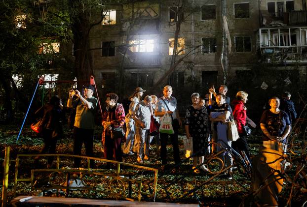 Firefighters work at the site of an apartment building hit by a Russian missile strike in Kyiv