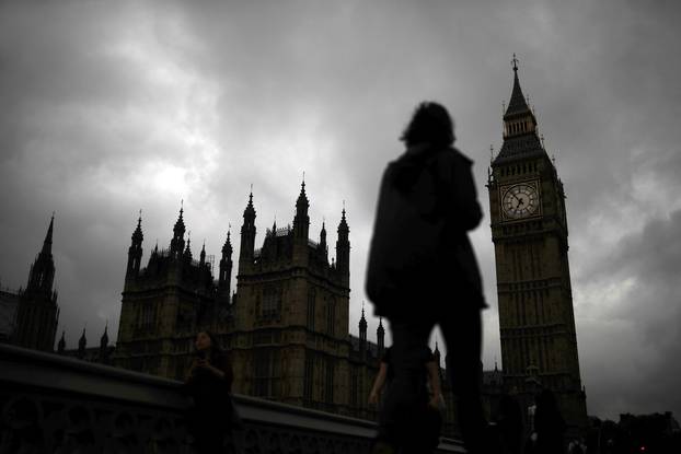 A woman walks past the Houses of Parliament and the Big Ben clock tower, on the day of the EU referendum, in central London