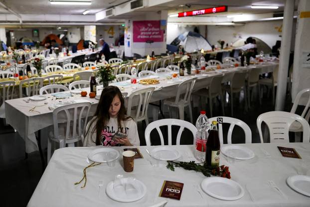 Israelis hold a Passover Seder in an underground parking garage used as a public bomb shelter, in Tel Aviv