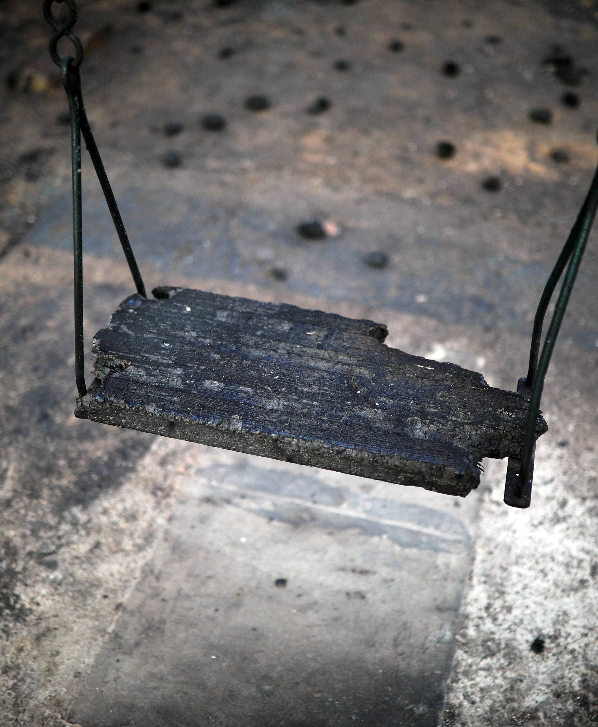 A burnt seesaw is seen in a playground following a wildfire at the village of Mati