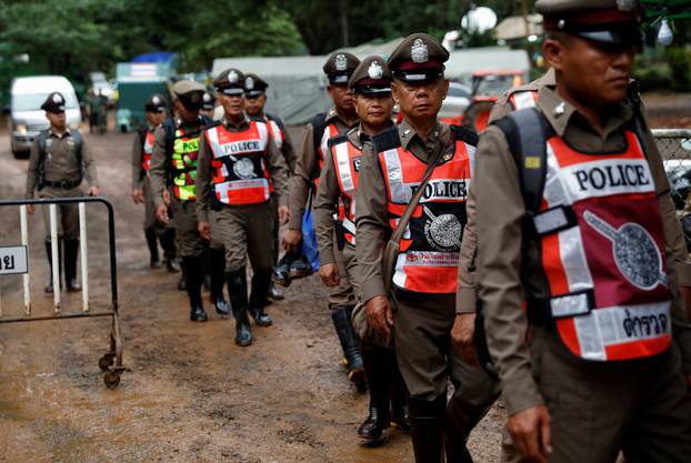 Police officers walk near Tham Luang cave complex, as members of an under-16 soccer team and their coach have been found alive according to a local media report, in Chiang Rai