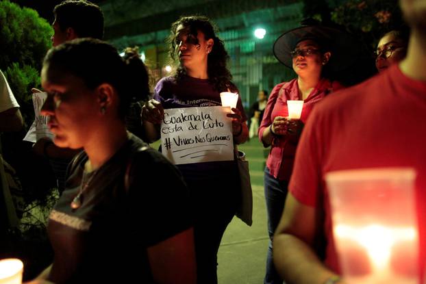 A woman holds a sign that reads " Guatemala is in mourning. Alive we want them" during a vigil for vitims of a fire at the Virgen de Asuncion home in Guatemala, in Managua, Nicaragua