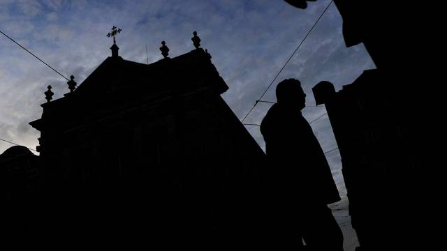 FILE PHOTO: People walk by a church on the day Portugal's commission investigating allegations of historical child sexual abuse by members of the Portuguese Catholic church will unveil its report, in Lisbon