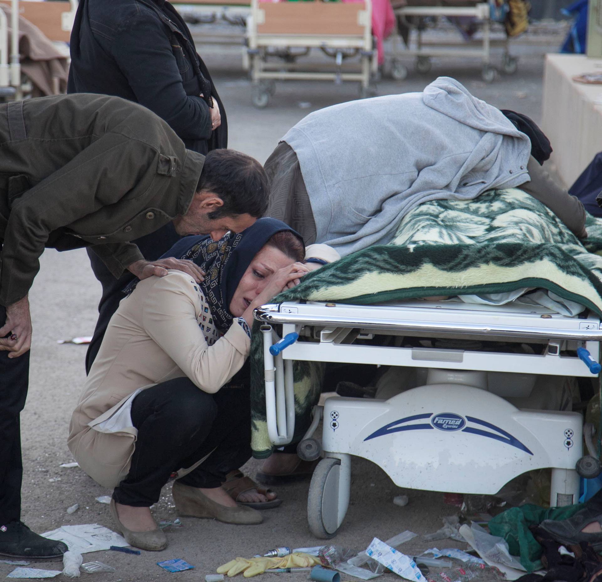 A woman reacts next to a dead body following an earthquake in Sarpol-e Zahab county in Kermanshah