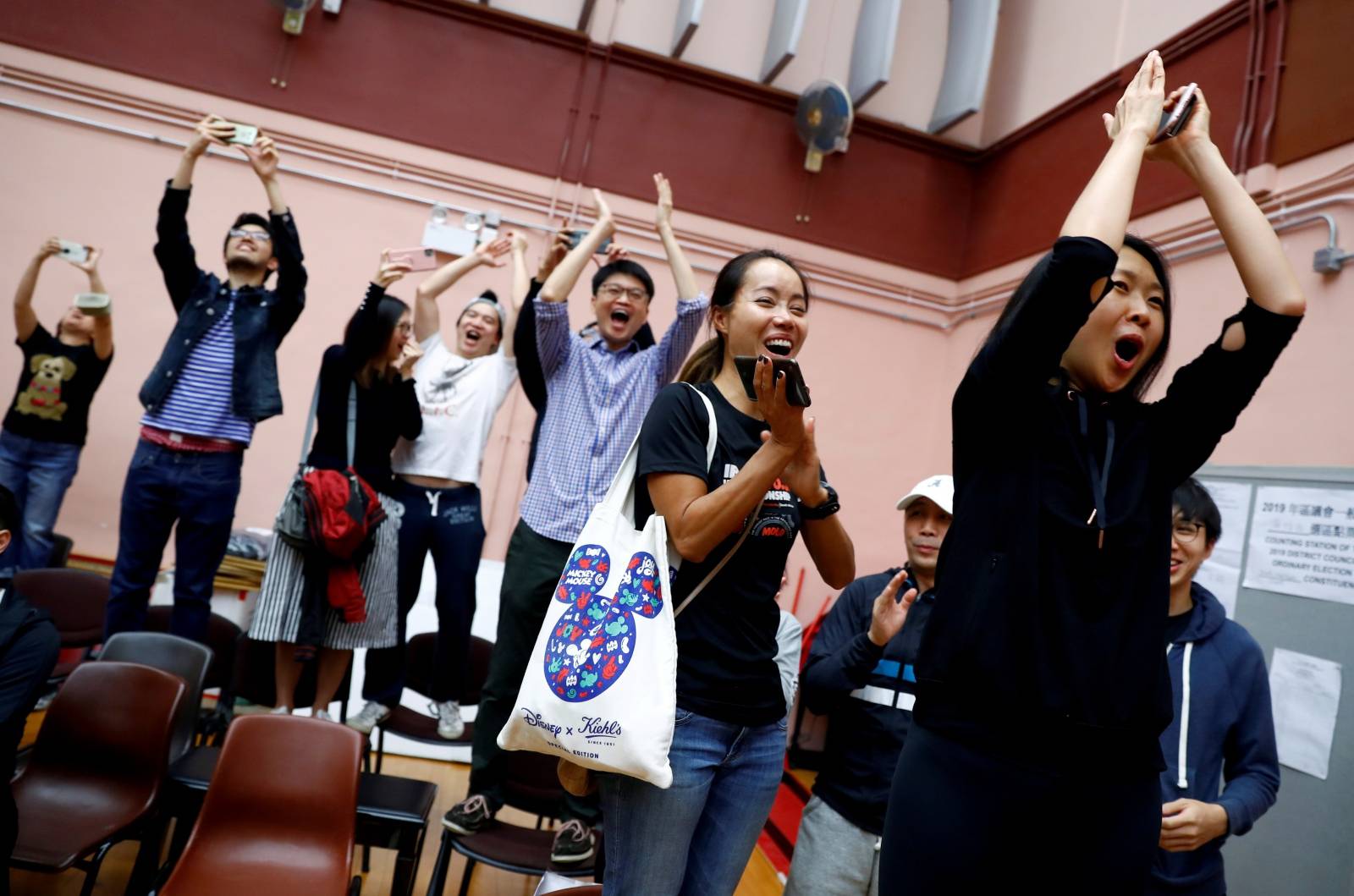 Supporters of local candidate Kelvin Lam celebrate at a polling station in the South Horizons West district in Hong Kong