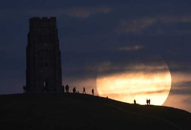 The moon rises near Glastonbury Tor a day before the "supermoon" spectacle, in Glastonbury