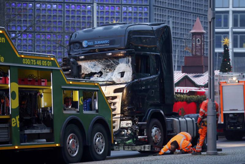 Rescue workers inspect the crashed truck at a Berlin Christmas market