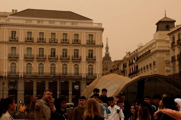 Tourists visit Puerta del Sol square as storm Celia blew sand from the Sahara desert over Madrid