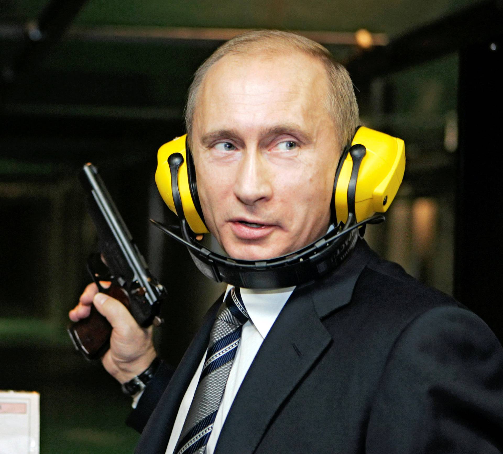 FILE PHOTO: Russian President Putin stands with a gun at a shooting gallery in Moscow