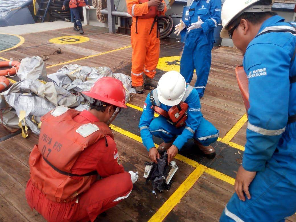 Workers of PT Pertamina examine recovered debris of what is believed to be from the crashed Lion Air flight JT610, onboard Prabu ship owned by PT Pertamina, off the shore of Karawang regency