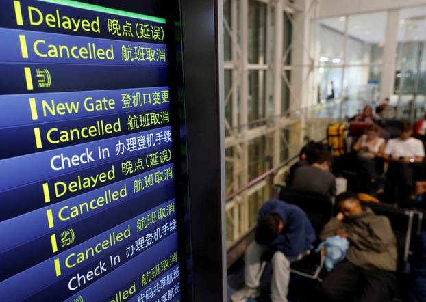 Passengers rest at Haneda Airport as many flights are delayed and cancelled due to Typhoon Dujuan, in Tokyo