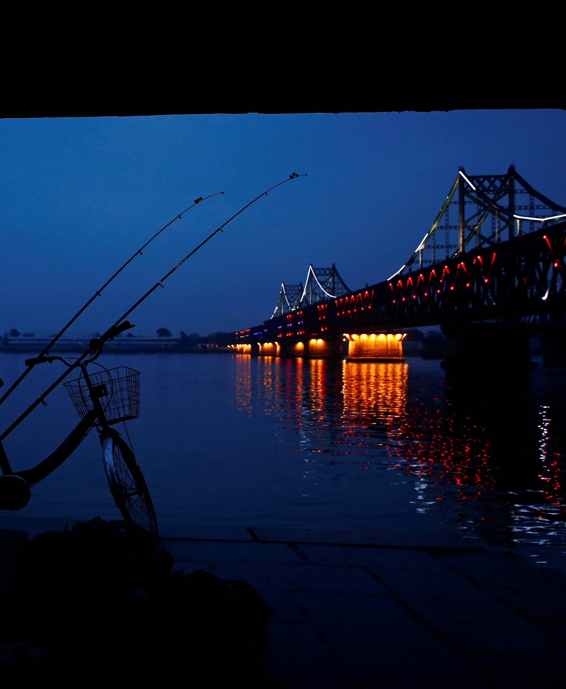 A man looks across Yalu River towards North Korea as he stands next to the bridge that connects China's Dandong, Liaoning province and North Korea's Sinuiju 