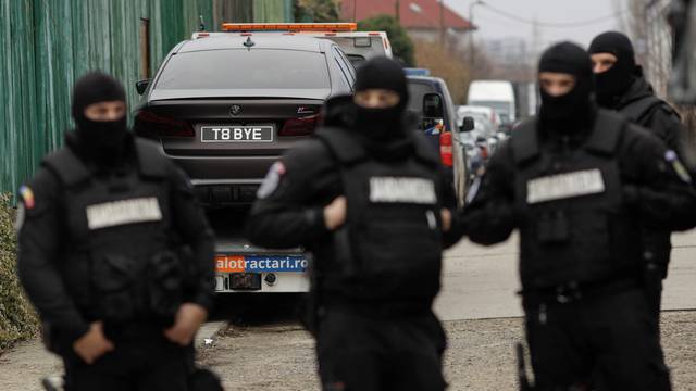 Romanian officials transport the cars seized from the Tate compund to a storage location