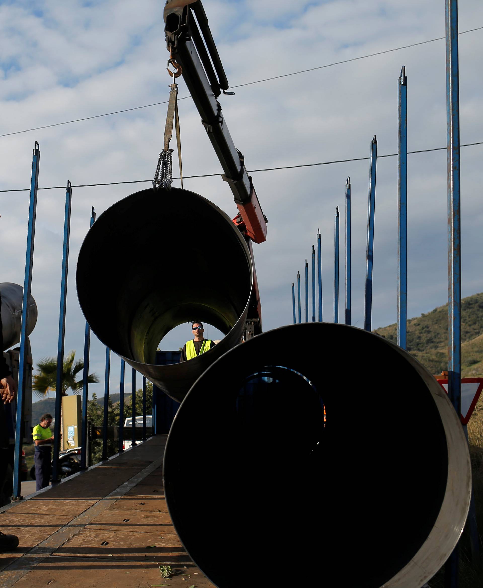 Workers move steels tubes, which will be used to protect a deep well, next to the area where Julen, a Spanish two-year-old boy fell into the well four days ago when the family was taking a stroll through a private estate, in Totalan