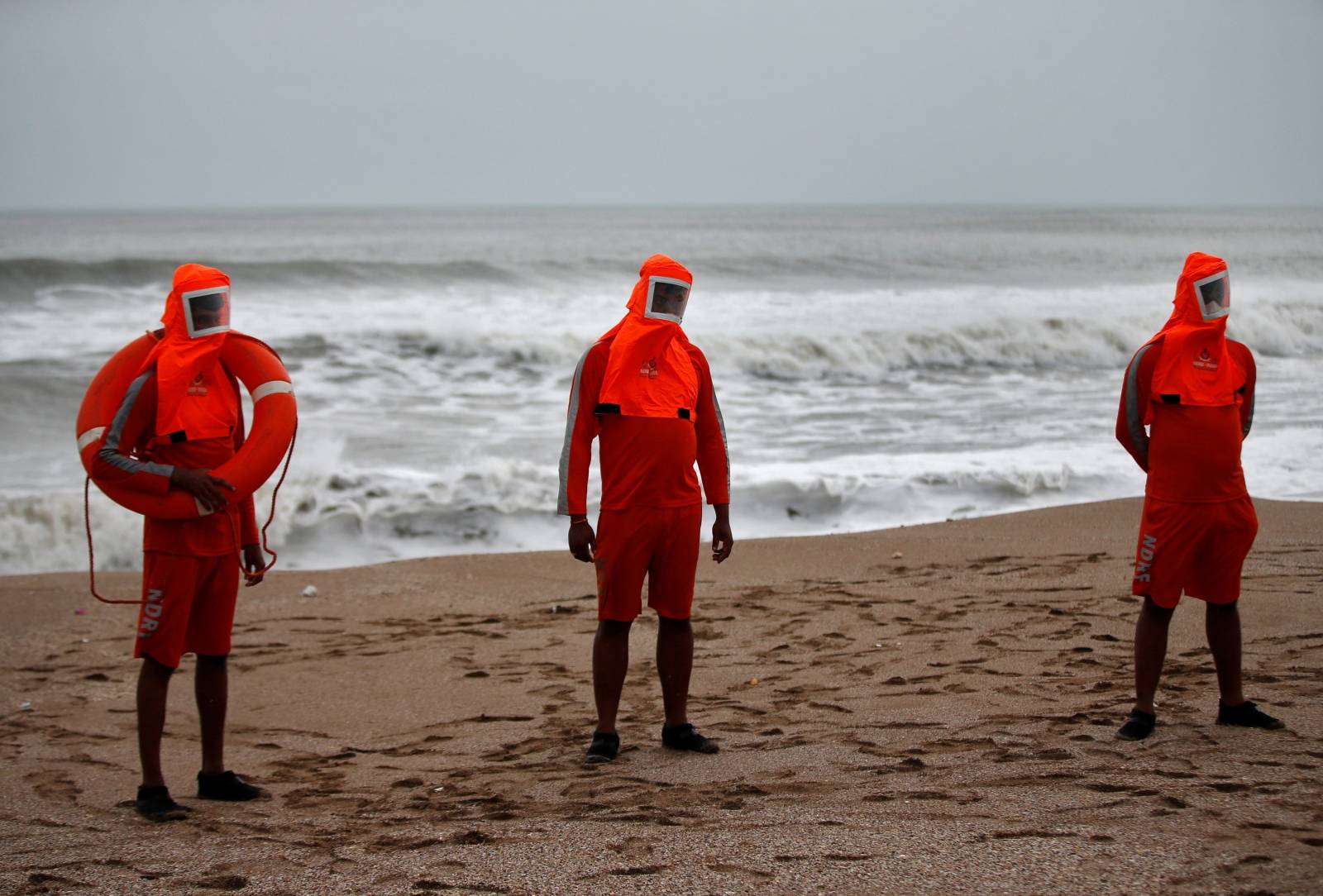 Members of NDRF stand guard along a shore ahead of Cyclone Tauktae in Veraval