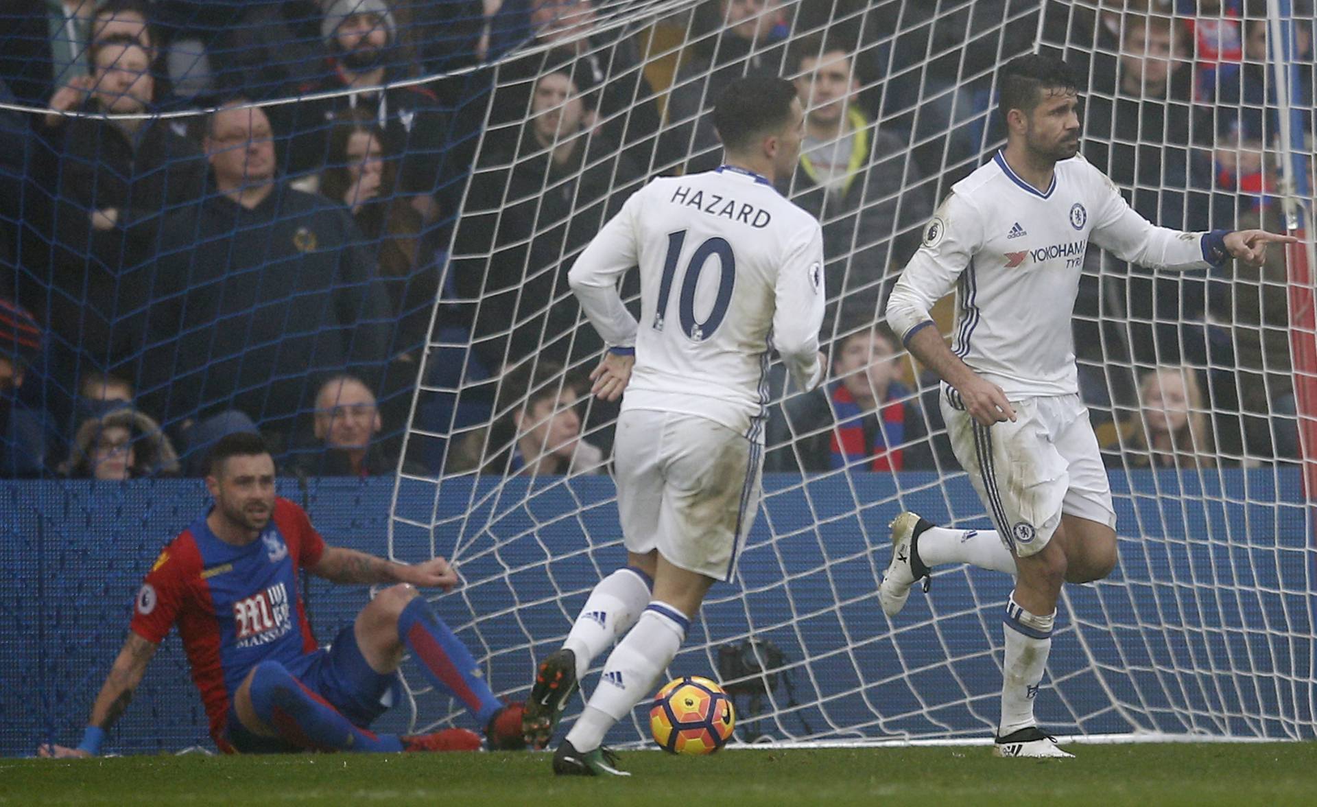 Chelsea's Diego Costa celebrates scoring their first goal as Crystal Palace's Damien Delaney looks dejected