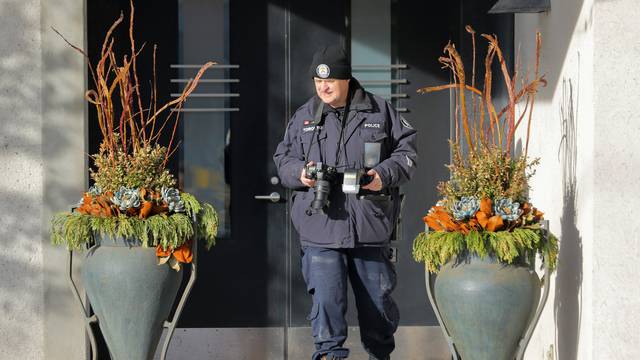 A police forensics photographer works outside the home of billionaire founder of Canadian pharmaceutical firm Apotex Inc. in Toronto