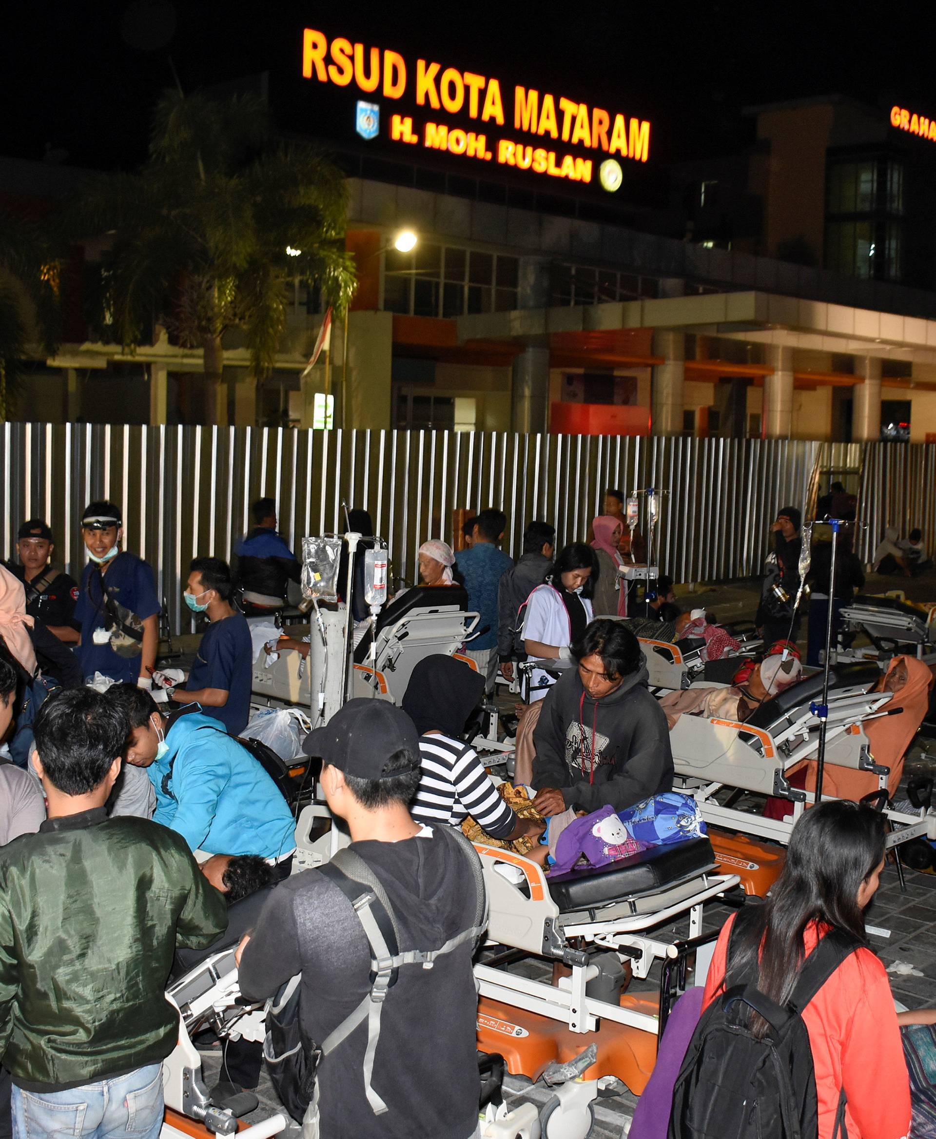 Patients are evacuated outside to the Mataram City hospital parking lot after a strong earthquake in Mataram, Lombok island