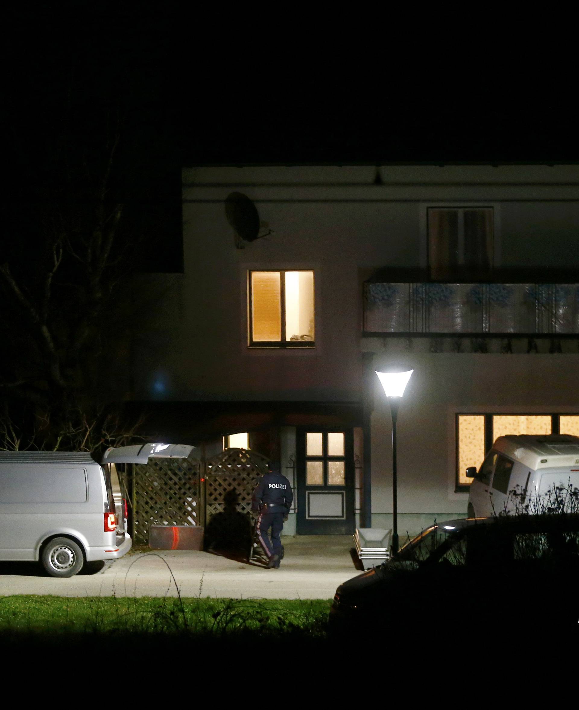 Coffins ans a hearse stand in front of a house where six people were found dead in Boeheimkirchen