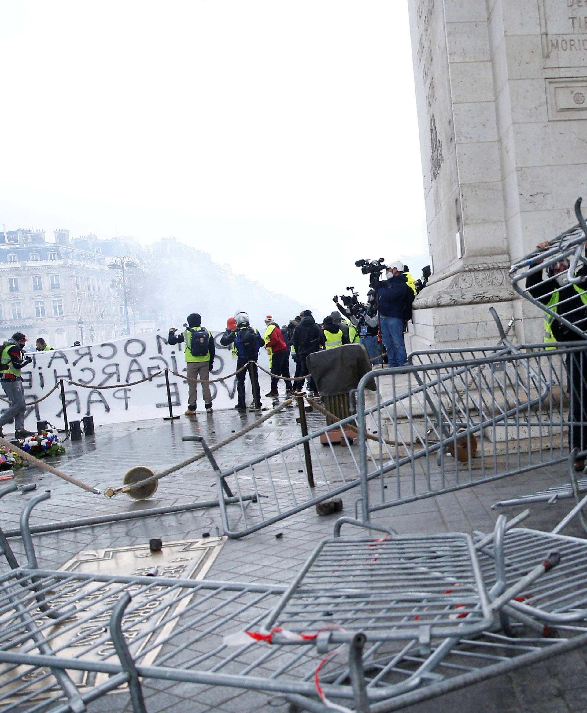 Protesters wearing yellow vests, a symbol of a French drivers' protest against higher diesel taxes, install a barricade under the Arc de Triomphe during clashes at the Place de l'Etoile in Paris