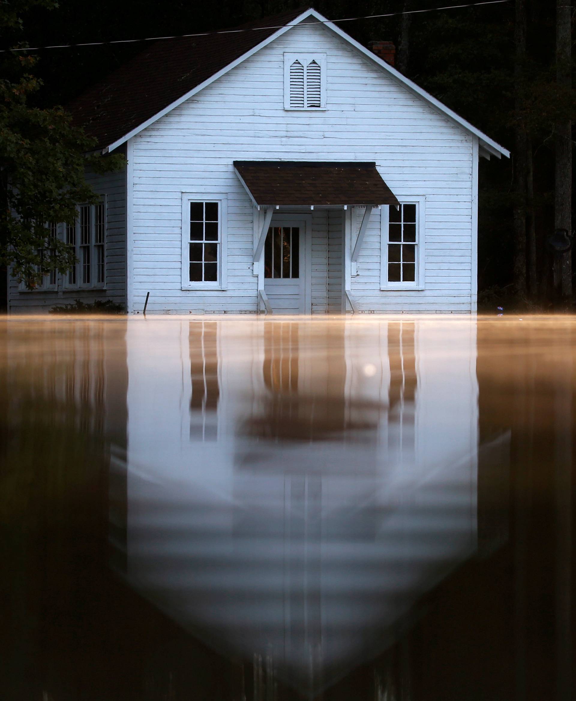 Mist rises off the water as a flooded building is pictured after Hurricane Matthew passes in Lumberton