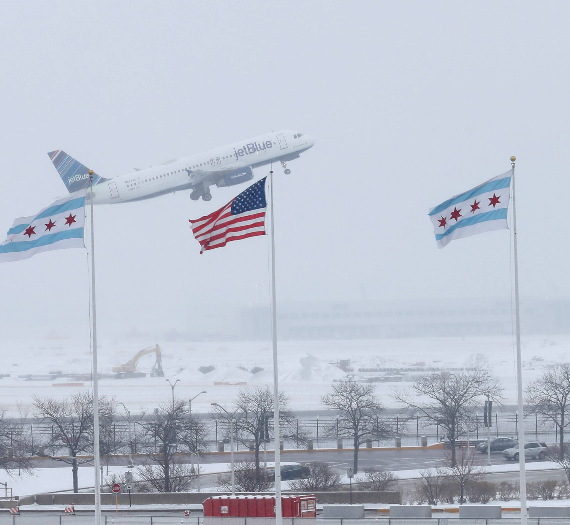A JetBlue plane departs during the snowstorm at O'Hare International Airport in Chicago