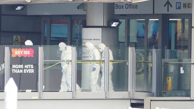Forensics investigators work at the entrance to the Manchester Arena