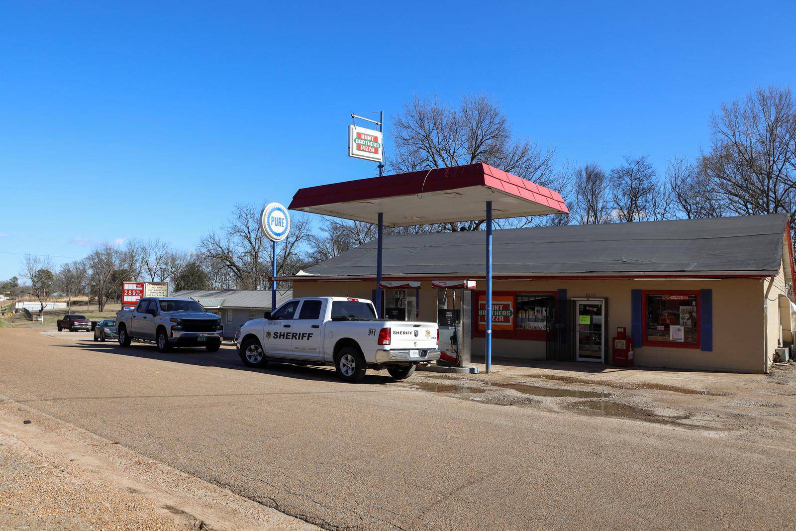 A vehicle of the Tate County Sheriff is seen parked outside a gas station convenience store after a shooting, in Arkabutla