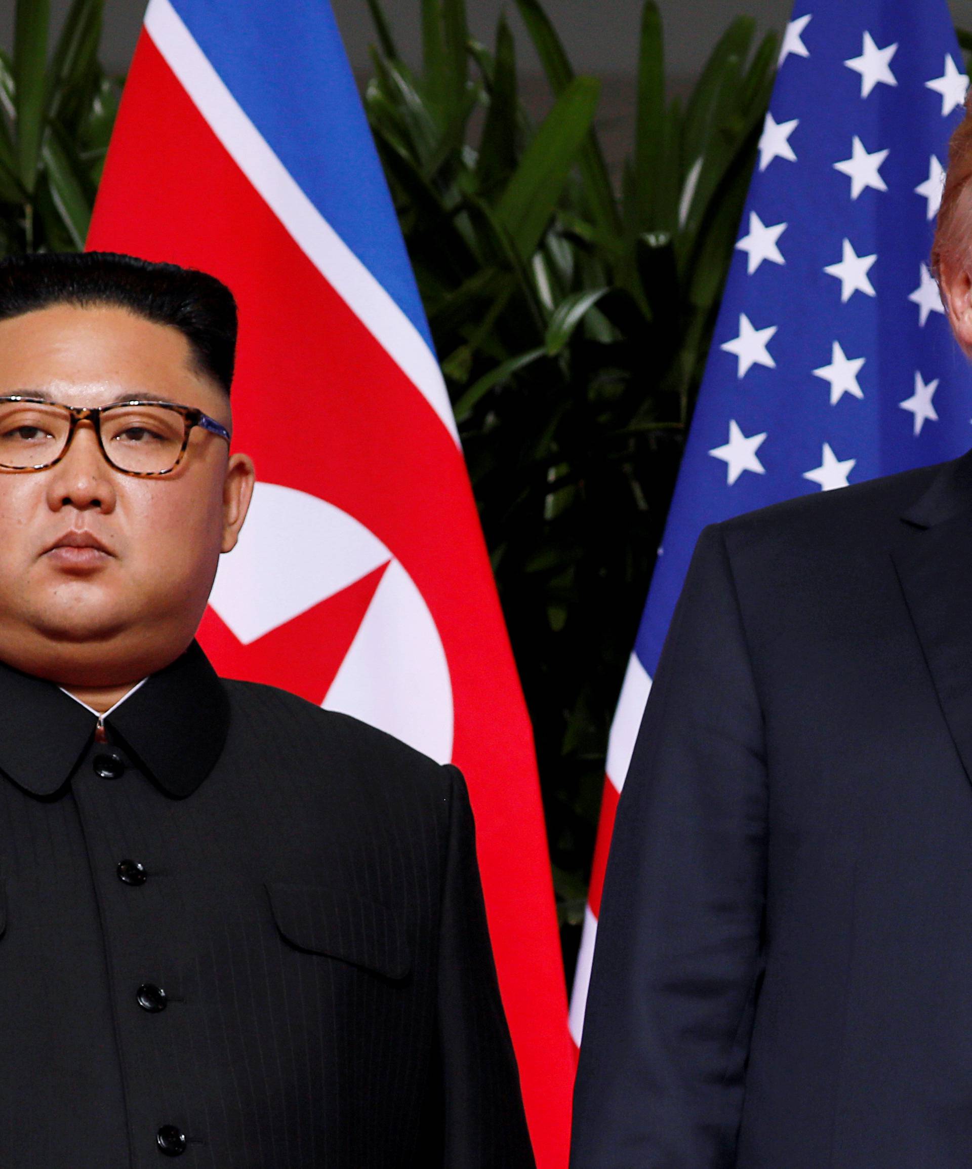 FILE PHOTO: U.S. President Donald Trump and North Korean leader Kim Jong Un react at the Capella Hotel on Sentosa island in Singapore