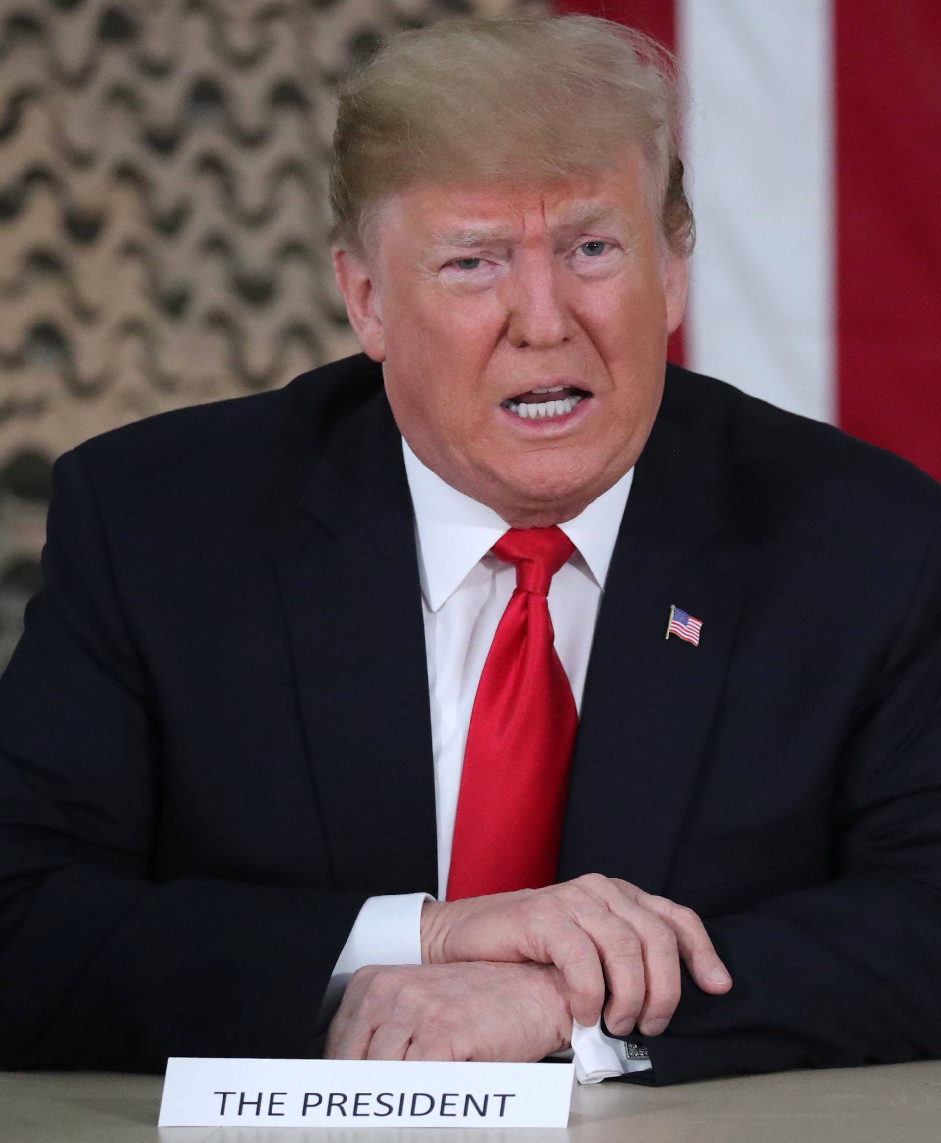 U.S. President Trump speaks to reporters during an unannounced visit to Al Asad Air Base