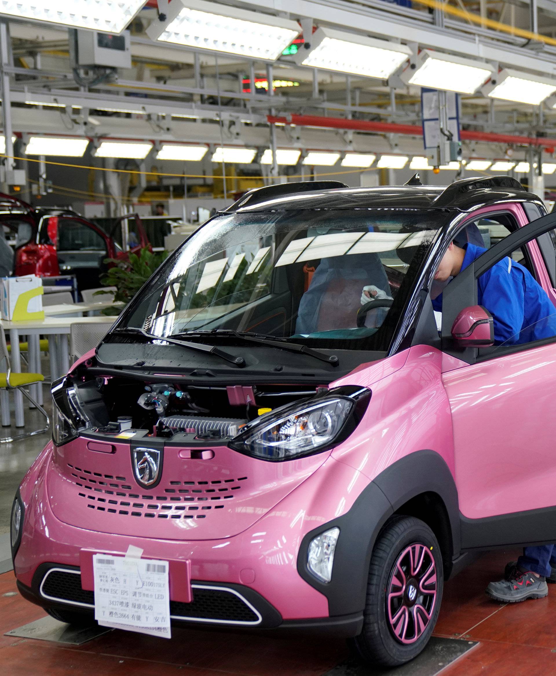 FILE PHOTO: Workers inspect Baojun E100 all-electric battery cars at a final assembly plant operated by General Motors Co and its local joint-venture partners in Liuzhou
